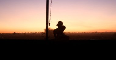 A Sudanese refugee girl from el-Fasher sits on a wall after sunset in the middle of the Tine transit camp, in eastern Chad, Nov. 23, 2025. (Reuters Photo)

     TPX IMAGES OF THE DAY