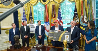 President Donald Trump speaks, holding a large ticket representing a ticket for the World Cup final in the Oval Office of the White House, Washington, U.S., Aug. 22, 2025. (AP Photo)
