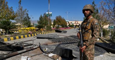 An Army soldier stands guard next to damages at the main gate of an army-run cadet college that was assaulted by militants on Monday, in Wana, a city in the northwestern Pakistani district South Waziristan bordering with Afghanistan, Nov. 13, 2025. (AP Photo)