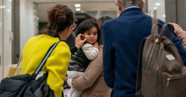 A court observer squeezes the cheek of a respondent&#039;s child at the U.S. Immigration Court in Manhattan, in New York City, U.S., Dec. 2, 2025. (Reuters Photo)