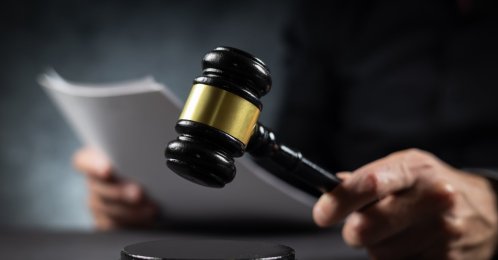 A judge with a paper document pronouncing a sentence in a court of law. (Shutterstock Photo)
