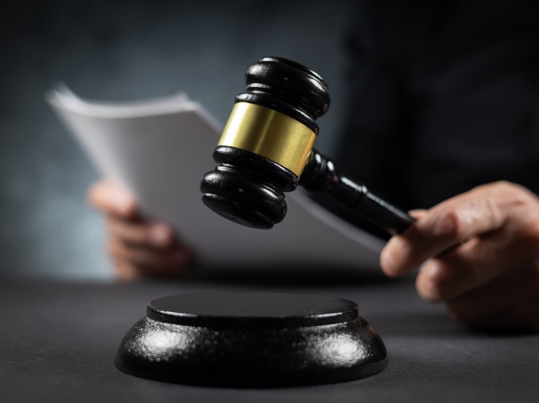 A judge with a paper document pronouncing a sentence in a court of law. (Shutterstock Photo)