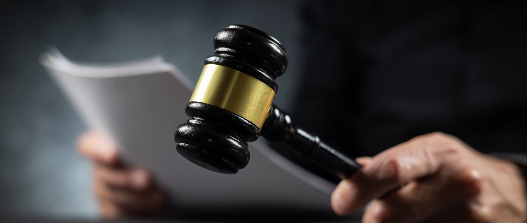 A judge with a paper document pronouncing a sentence in a court of law. (Shutterstock Photo)