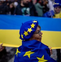 A woman a hat and flag with the EU symbols stands in front of a large Ukrainian flag in Prague, Czech Republic, Nov. 17, 2025. (EPA Photo)