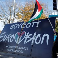 Pro-Palestinian protestors hold a flag and a banner outside the RTE (Radio Telefis Eireann) Irish public service broadcaster television studios as demonstrators call for an Irish boycott of the 2026 Eurovision Song Contest if there is Israeli participation, in Dublin, Ireland, Nov. 1, 2025. (Reuters File Photo)