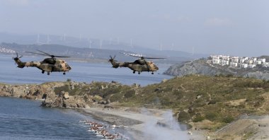 Turkish army helicopters prepare to land close to a touristic area after an amphibious landing during EFES 2018 drills in the Aegean Sea near Izmir, western Türkiye, May 10, 2018. (AP Photo)