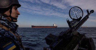A serviceman in Ukraine&#039;s coast guard mans a gun on a patrol boat as a cargo ship passes by in the Black Sea, Feb. 7, 2024. (Reuters File Photo)