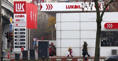 People pass by a Lukoil gas station in Bucharest, Romania, Dec. 3, 2025. (EPA Photo)
