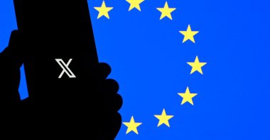This illustration photograph shows the logo of X social media platform displayed on a smartphone in front a Euopean Union flag, Brussels, Belgium, Sept. 29, 2025. (AFP Photo)