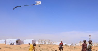 Sudanese refugee children from Darfur fly a handmade kite past newly built tents, inside the Touloum refugee camp, in Wadi Fira province, eastern Chad, Nov. 30, 2025. (Reuters Photo)