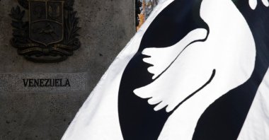 A demonstrator holds a flag showing a peace dove next to Venezuela’s national coats of arms during a demonstration to protest against U.S. military action against Venezuela, San Francisco, California, U.S., Dec. 6, 2025. (Reuters Photo)