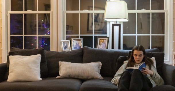 Teenager Sutton Bulkeley reads the novel &#039;Mockingjay&#039; by Suzanne Collins in the living room, in Westport, Connecticut, U.S., Feb. 16, 2024. (AP Photo)