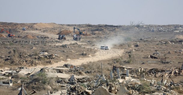 A machinery operates next to a Red Cross vehicle at an area within the so-called "yellow line" to which Israeli troops withdrew under the ceasefire, as Hamas says it continues to search for the bodies of deceased hostages in Gaza City, Nov. 12, 2025. (Reuters Photo)