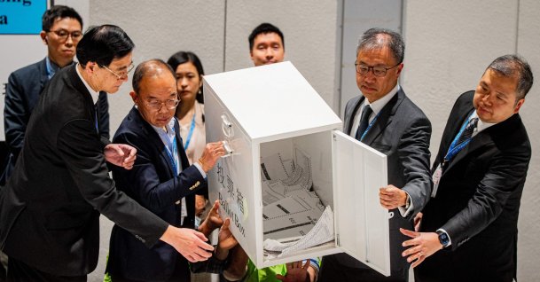 Secretary for Constitutional and Mainland Affairs Erick Tsang Kwok-wai (2L) helps empty the first ballot box after polls closed in the Legislative Council elections in Hong Kong, China, Dec. 7, 2025. (AFP Photo)