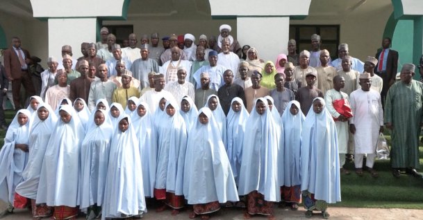 In this screengrab from a video, released schoolgirls wearing blue hijabs pose for photos with their parents and government officals after the girls were freed from captivity in Kebbi, Nigeria, Nov. 26, 2025. (Reuters Photo)