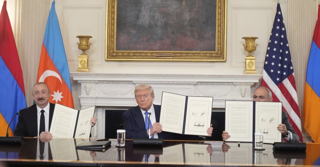 President Donald Trump (C), joined by Armenian Prime Minister Nikol Pashinyan (R), and Azerbaijan President Ilham Aliyev holds a signed trilateral agreement during a ceremony in the State Dining Room of the White House, in Washington DC, U.S.,  Aug. 8, 2025. (AP Photo)