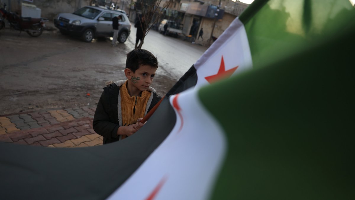A child holds a flag amid celebrations in Tal Rifaat, which was cleansed from PKK/YPG terrorists, to mark the first anniversary of Bashar Assad&#039;s fall, in Tal Rifaat, Syria, Dec. 1, 2025. (AA Photo)