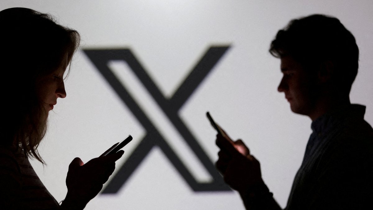 Teenagers pose for a photo while holding smartphones in front of an X logo in this illustration, Sept. 11, 2025. (Reuters Photo)