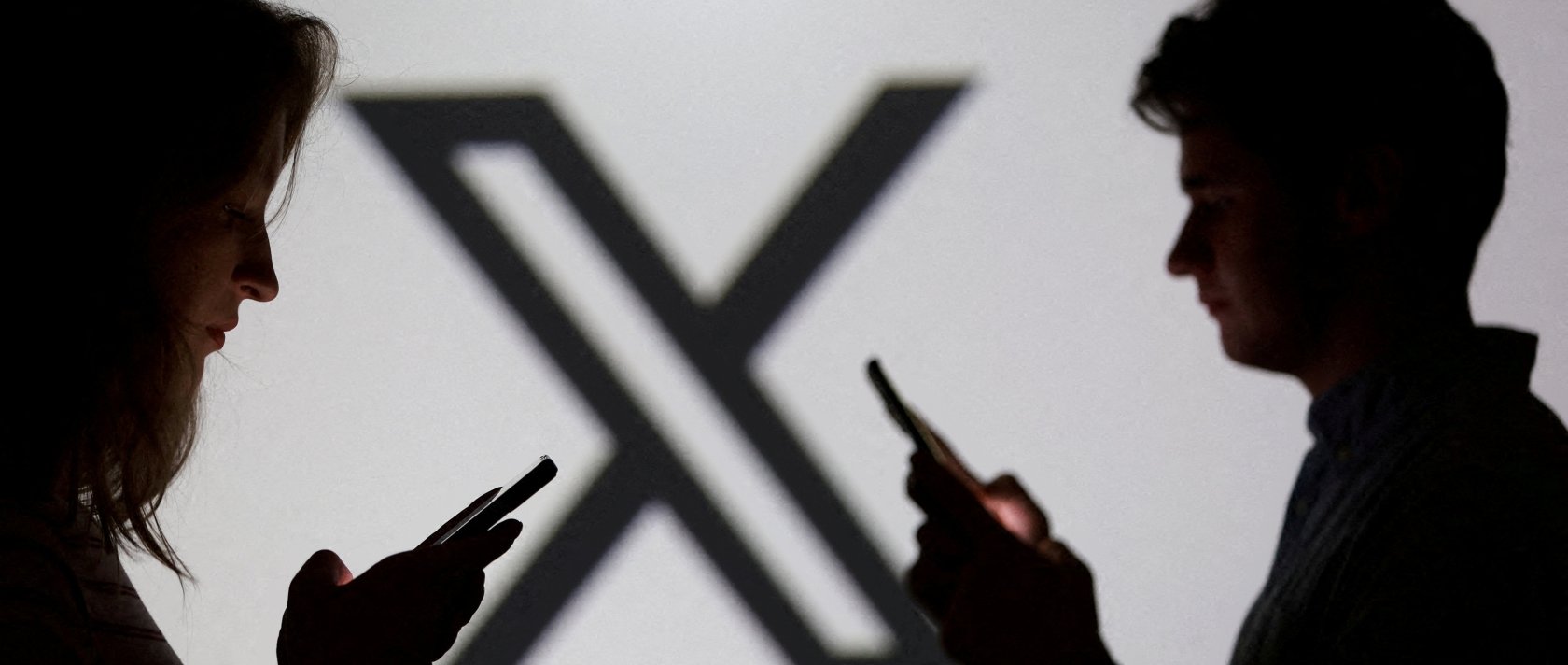Teenagers pose for a photo while holding smartphones in front of an X logo in this illustration, Sept. 11, 2025. (Reuters Photo)