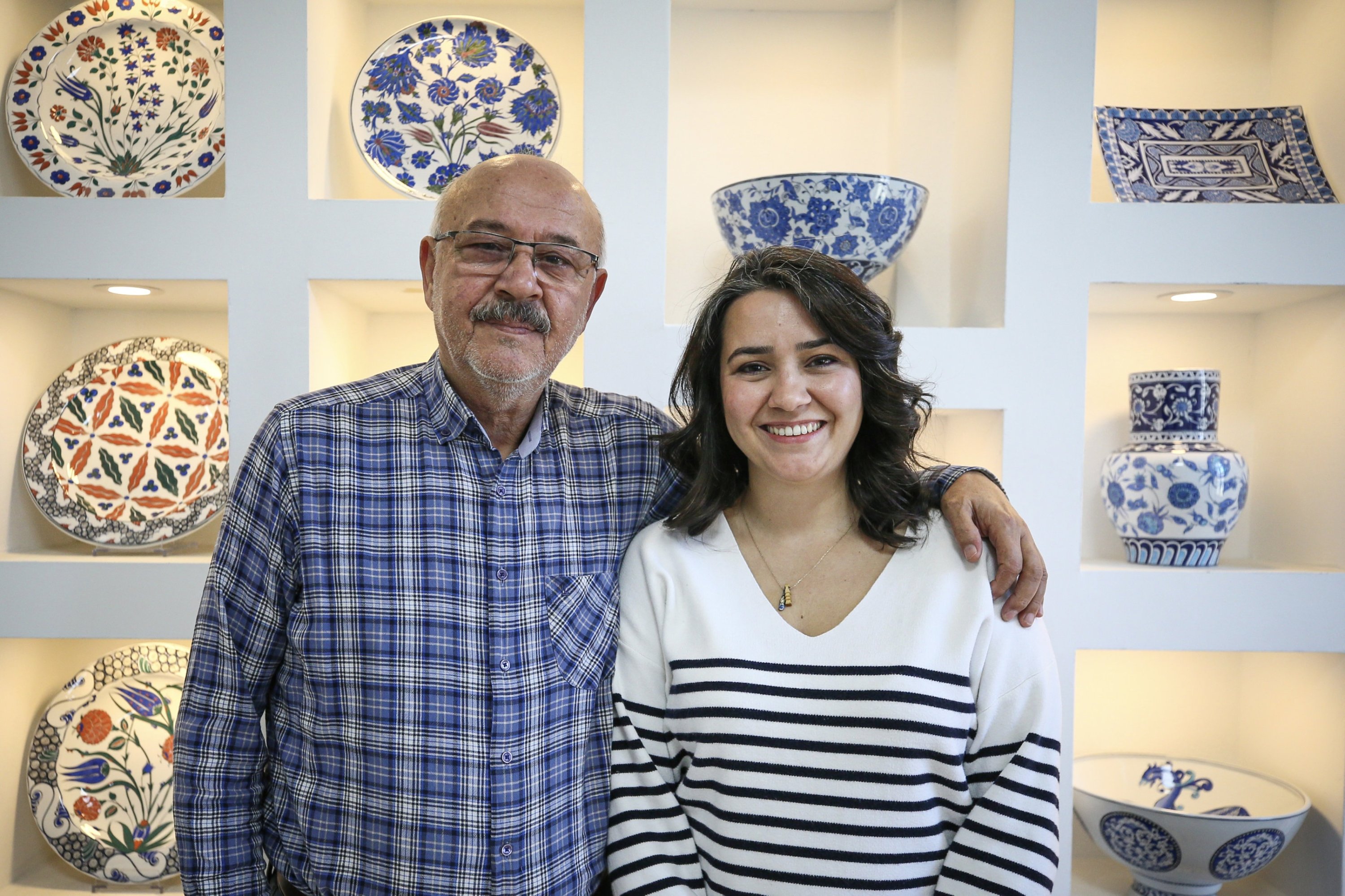 Mahmut Çalışkan, cofundador y director técnico, y su hija Ceren Çalışkan Eken posan con cerámicas de Iznik expuestas detrás de ellos, Bursa, Türkiye, 3 de diciembre de 2025. (Foto AA)