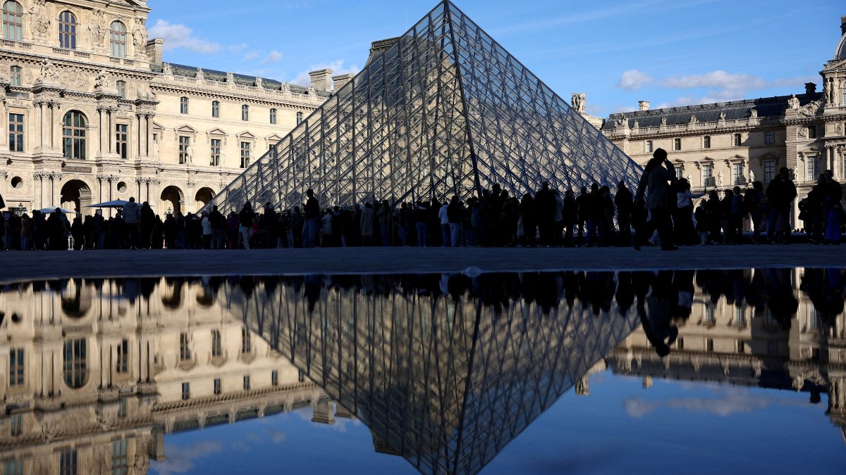 People stand outside the Louvre Museum, after French police arrested suspects in the Louvre heist case, Paris, France, Oct. 26, 2025. (Reuters Photo)