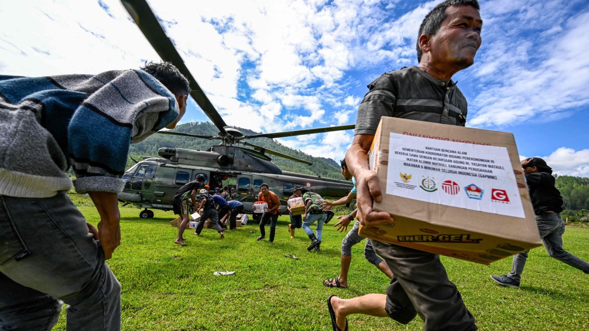 Residents carry supplies distributed by Indonesian air force personnel in flood-affected areas in Bener Meriah district, Aceh province, Indonesia, Dec. 4, 2025. (AFP Photo)