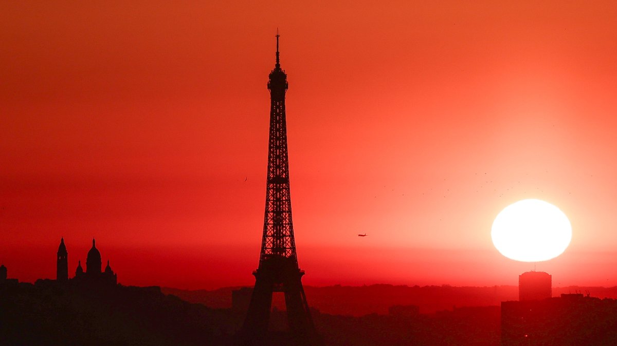 The sun rises by the Eiffel Tower and the Sacre Coeur Basilica on top of the Montmartre hill, Paris, France, July 1, 2025. (AFP Photo)