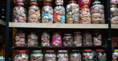 Glass jars and aquarium tanks packed with thousands of vintage doll heads fill the display shelves of an antique shop, Izmit, Türkiye, Dec. 7, 2025. (IHA Photo)
