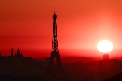 The sun rises by the Eiffel Tower and the Sacre Coeur Basilica on top of the Montmartre hill, Paris, France, July 1, 2025. (AFP Photo)