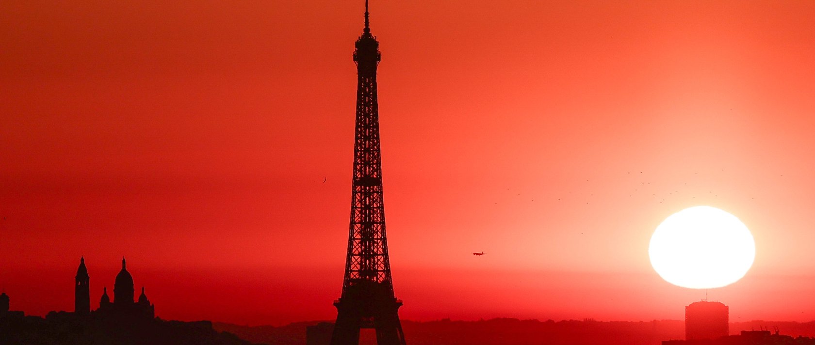 The sun rises by the Eiffel Tower and the Sacre Coeur Basilica on top of the Montmartre hill, Paris, France, July 1, 2025. (AFP Photo)