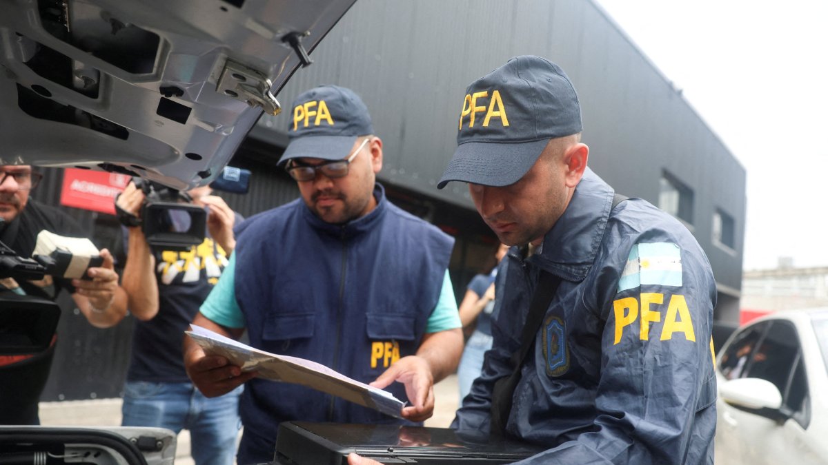A member of the Argentine Federal Police places a seized printer inside the trunk of a car at the Claudio Chiqui Tapia stadium, which belongs to the team Barracas Central, after a raid, amid an investigation into alleged money laundering involving the Argentine Football Association and a group of clubs, according to local media, Buenos Aires, Argentina, Dec. 9, 2025. (Reuters Photo)