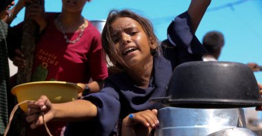 A Palestinian girl gestures as she waits to receive food from a charity kitchen, amid a hunger crisis, in Khan Younis, southern Gaza Strip, Palestine, Aug. 4, 2025. (Reuters Photo)