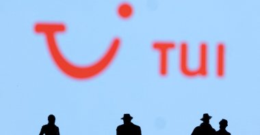 Figurines are seen in front of the TUI logo, Feb. 27, 2022. (Reuters Photo)