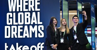 Participants take a photo next to a panel at the Take Off Istanbul 2025 summit, Istanbul, Türkiye, Dec. 10, 2025. (AA Photo)