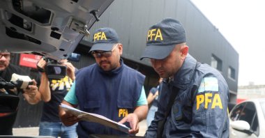 A member of the Argentine Federal Police places a seized printer inside the trunk of a car at the Claudio Chiqui Tapia stadium, which belongs to the team Barracas Central, after a raid, amid an investigation into alleged money laundering involving the Argentine Football Association and a group of clubs, according to local media, Buenos Aires, Argentina, Dec. 9, 2025. (Reuters Photo)