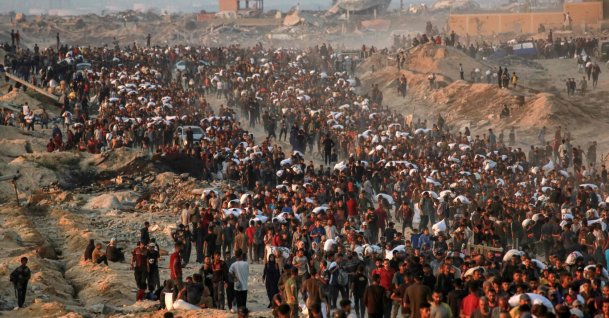 People carrying sacks of flour walk along al-Rashid Street in western Jabalia, June 17, 2025. (AFP File Photo)