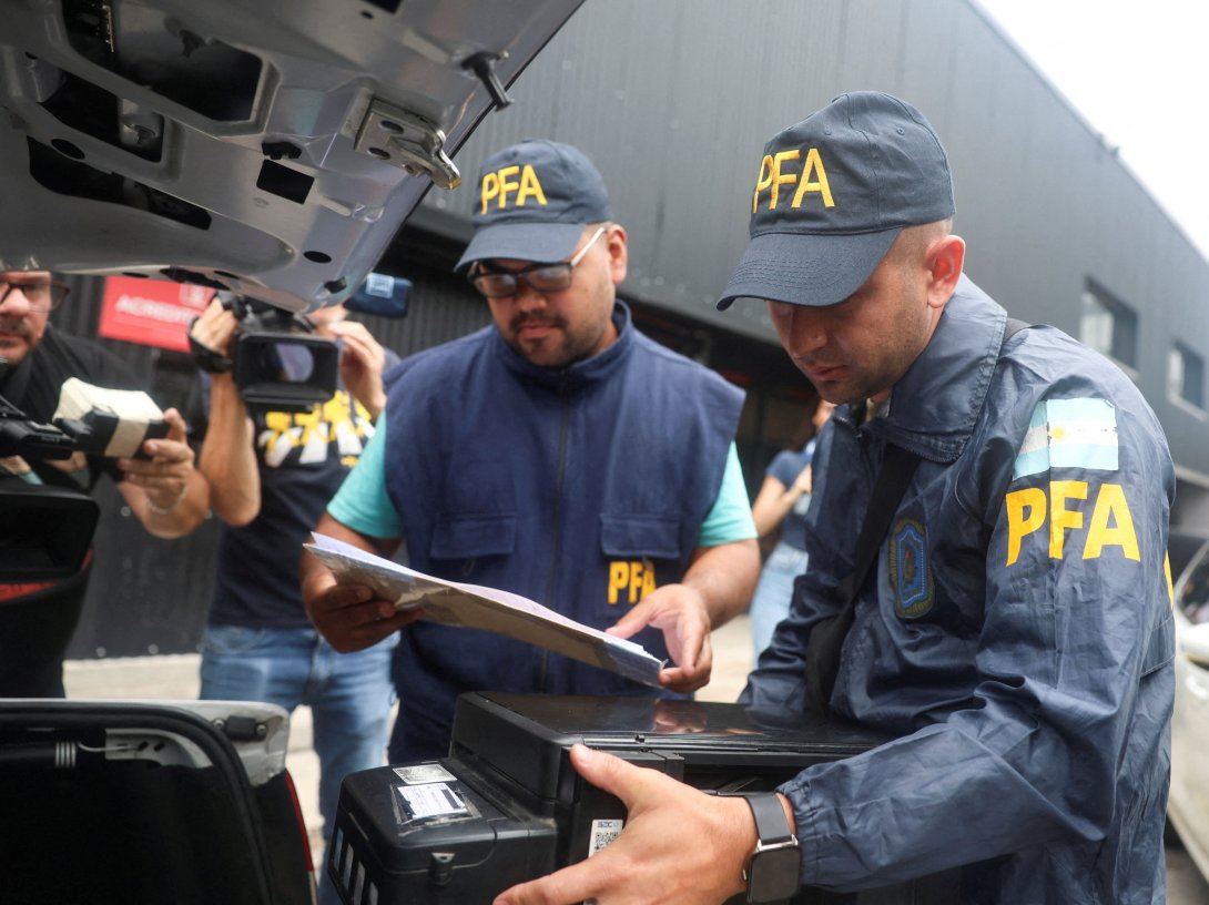 A member of the Argentine Federal Police places a seized printer inside the trunk of a car at the Claudio Chiqui Tapia stadium, which belongs to the team Barracas Central, after a raid, amid an investigation into alleged money laundering involving the Argentine Football Association and a group of clubs, according to local media, Buenos Aires, Argentina, Dec. 9, 2025. (Reuters Photo)