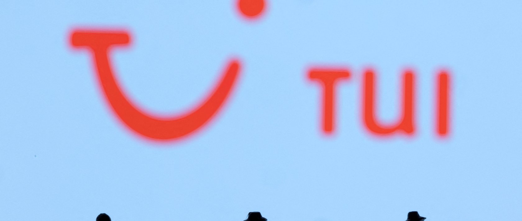 Figurines are seen in front of the TUI logo, Feb. 27, 2022. (Reuters Photo)