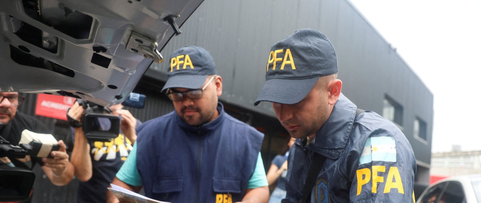 A member of the Argentine Federal Police places a seized printer inside the trunk of a car at the Claudio Chiqui Tapia stadium, which belongs to the team Barracas Central, after a raid, amid an investigation into alleged money laundering involving the Argentine Football Association and a group of clubs, according to local media, Buenos Aires, Argentina, Dec. 9, 2025. (Reuters Photo)