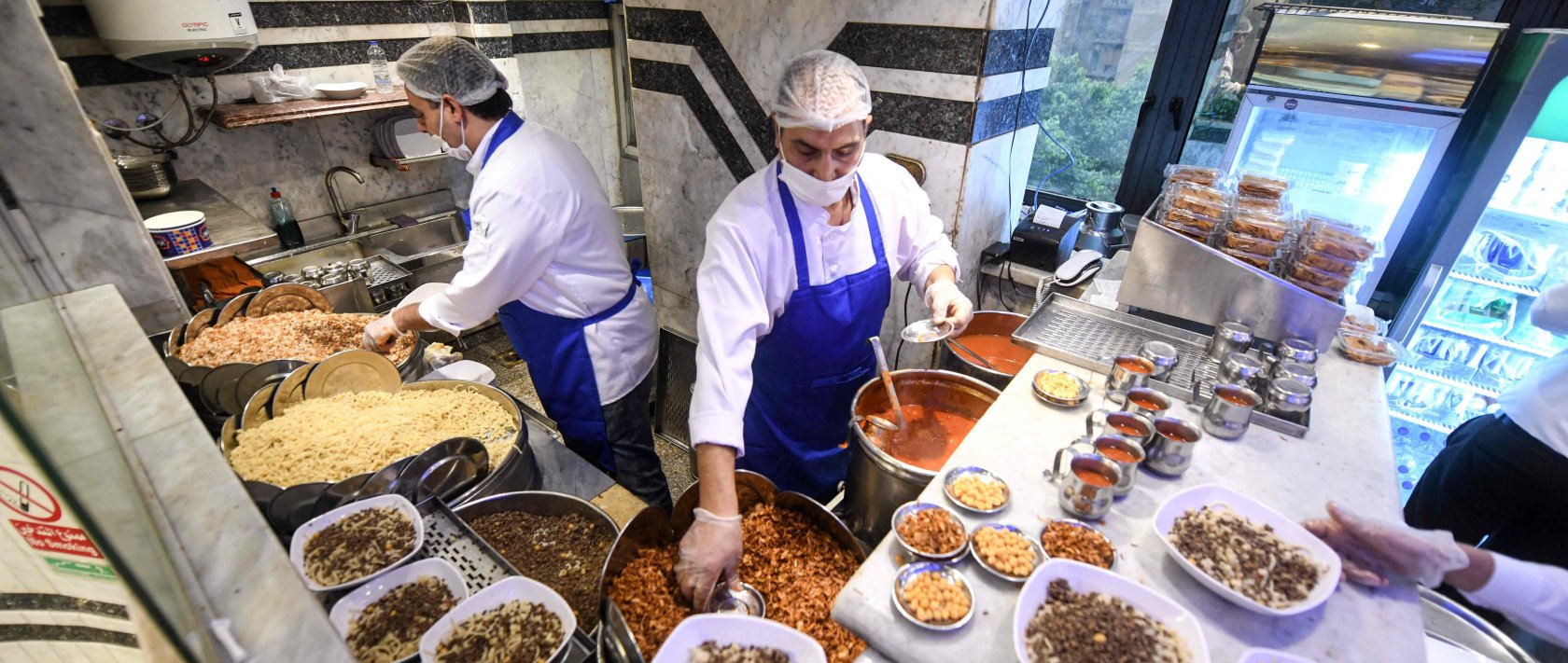  Egyptian chefs prepare a traditional dish in Arabic known as Koshary at Abou Tarek restaurant downtown Cairo, Dec. 10, 2025. (AFP Photo)
