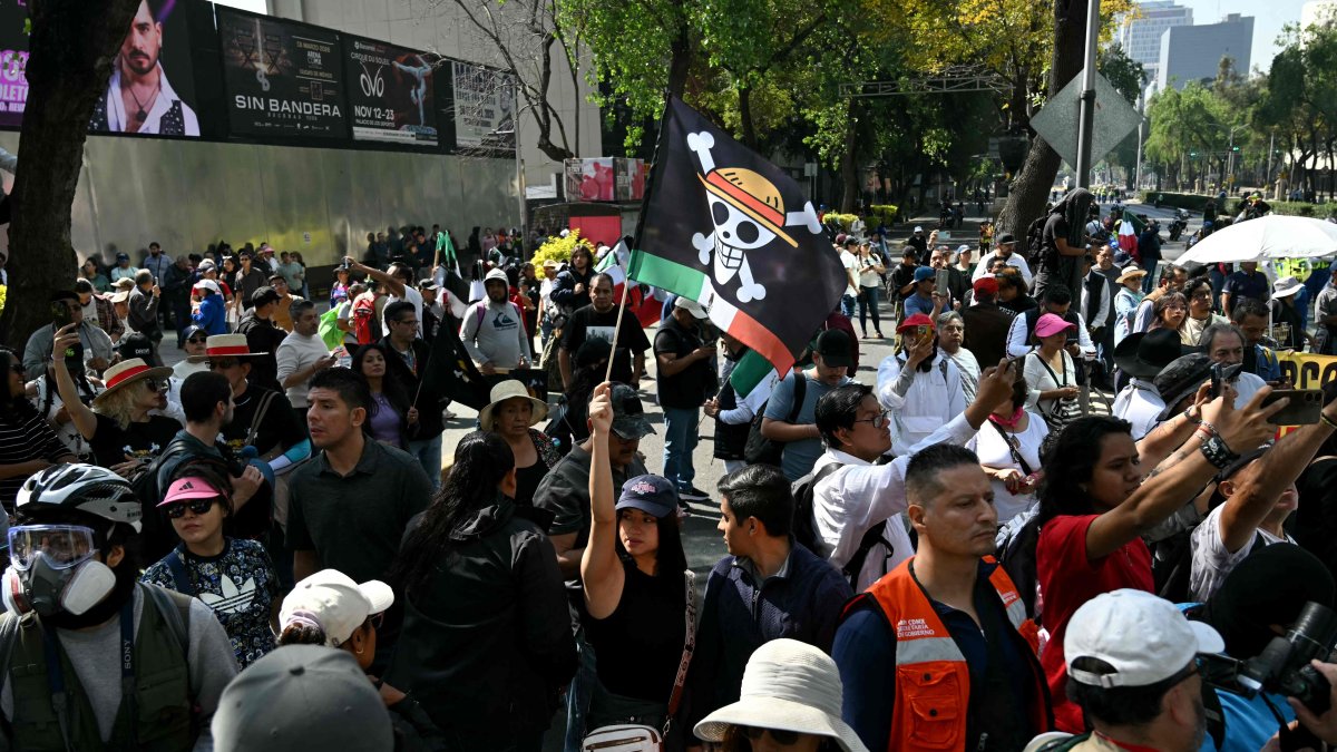 A protester holds a flag bearing the logo of the popular Japanese manga One Piece, a symbol adopted by Gen Z protest movements worldwide, during in a rally called by Generation Z against the government of Mexico&#039;s President Claudia Sheinbaum, along Reforma Avenue, Mexico City, Mexico, Nov. 20, 2025. (AFP Photo)