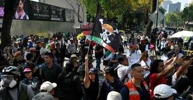 A protester holds a flag bearing the logo of the popular Japanese manga One Piece, a symbol adopted by Gen Z protest movements worldwide, during in a rally called by Generation Z against the government of Mexico&#039;s President Claudia Sheinbaum, along Reforma Avenue, Mexico City, Mexico, Nov. 20, 2025. (AFP Photo)