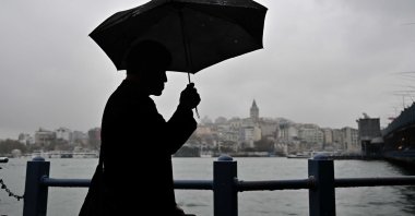 A man walks with an umbrella along the waterfront as light rainfall falls in Üsküdar, Istanbul, Türkiye, Dec. 7, 2025. (AA Photo)