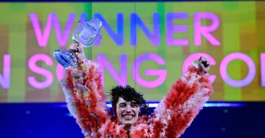 Singer Nemo, representing Switzerland with the song &quot;The Code,&quot; celebrates on stage with his trophy after winning the final of the 68th Eurovision Song Contest (ESC) 2024, May 11, 2024. (AFP File Photo)
