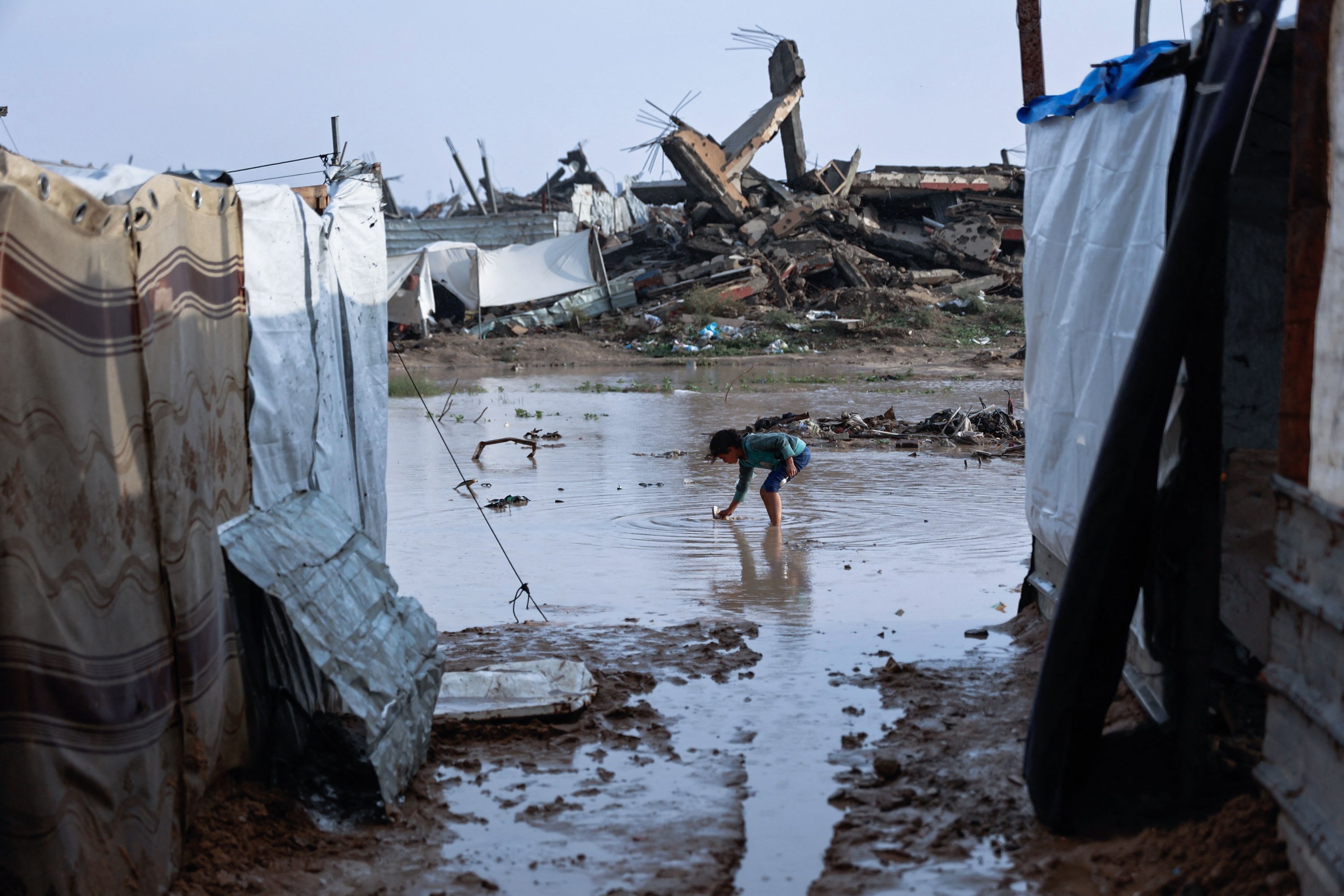 A girl stands in a pool of water at a makeshift camp sheltering displaced Palestinians after heavy rains in the Zeitoun neighbourhood of Gaza City, Palestine, Dec. 11, 2025. (AFP Photo)