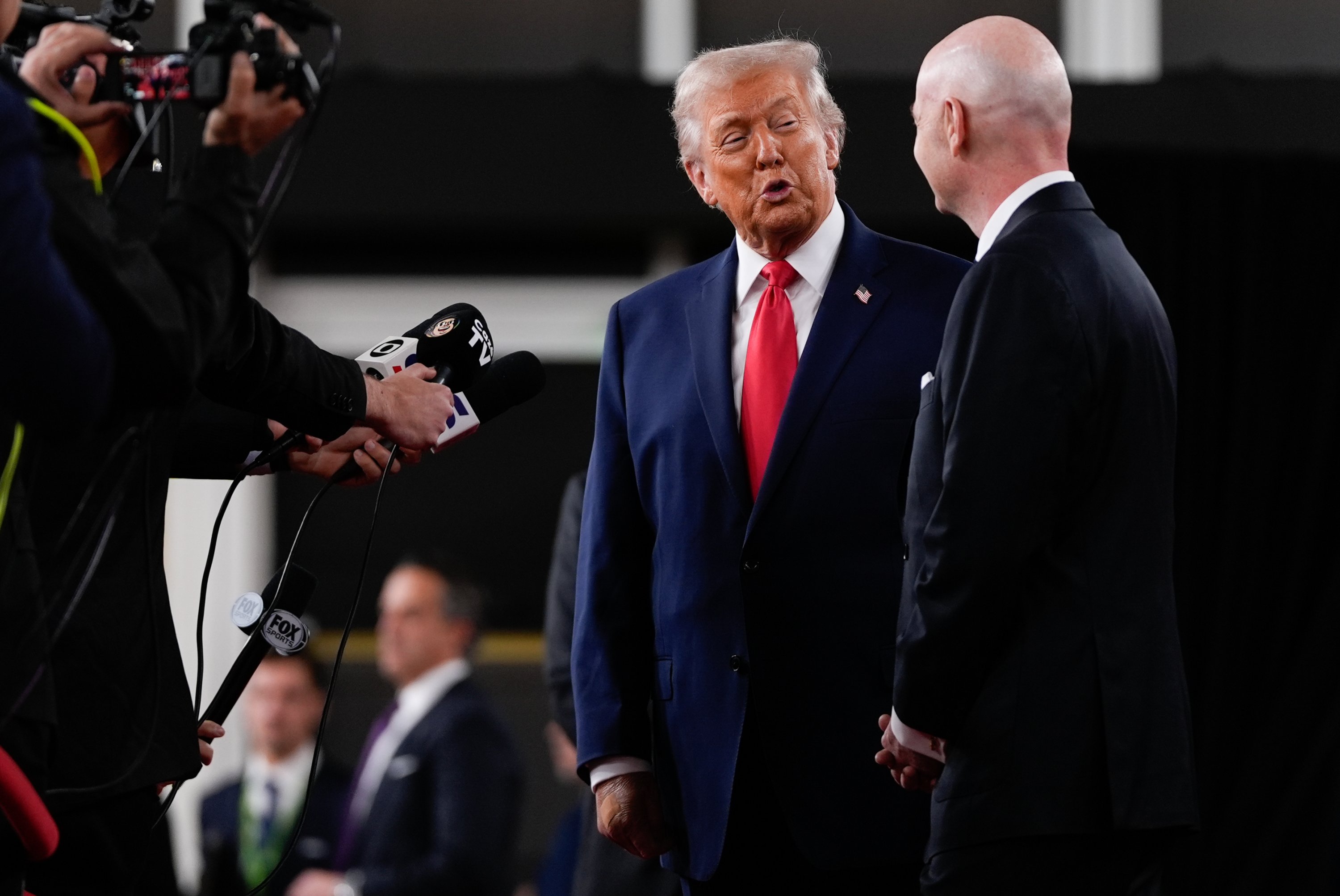 President Donald Trump (L) speaks to reporters on the red carpet as FIFA President Gianni Infantino watches, while arriving to attend the draw for the 2026 soccer World Cup at the Kennedy Center, Washington, U.S., Dec. 5, 2025. (AP Photo)