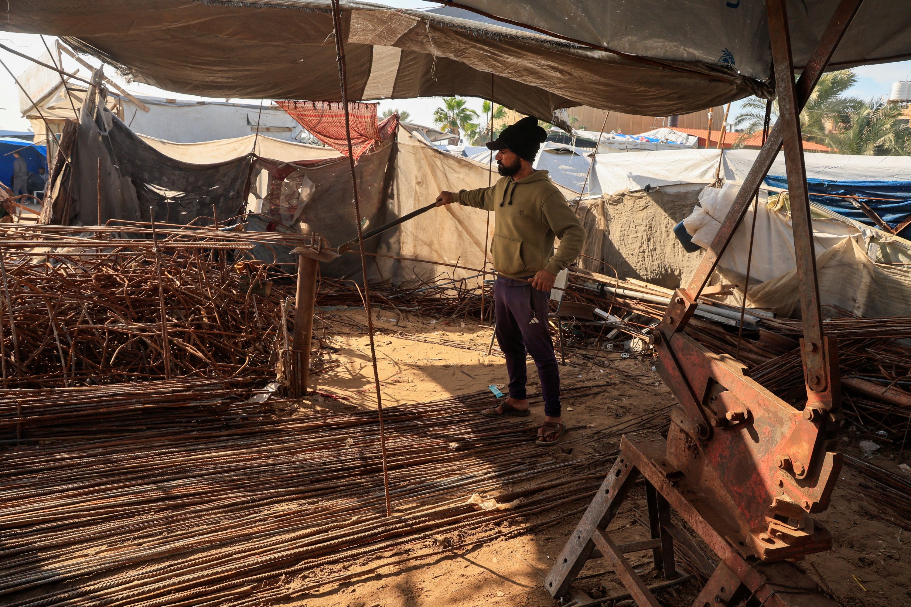 A Palestinian worker reshapes and straightens steel bars recovered from destroyed homes using basic tools inside a small workshop, amid a severe shortage of construction materials, Khan Younis, Gaza Strip, Palestine, Dec. 10, 2025. (Reuters Photo)