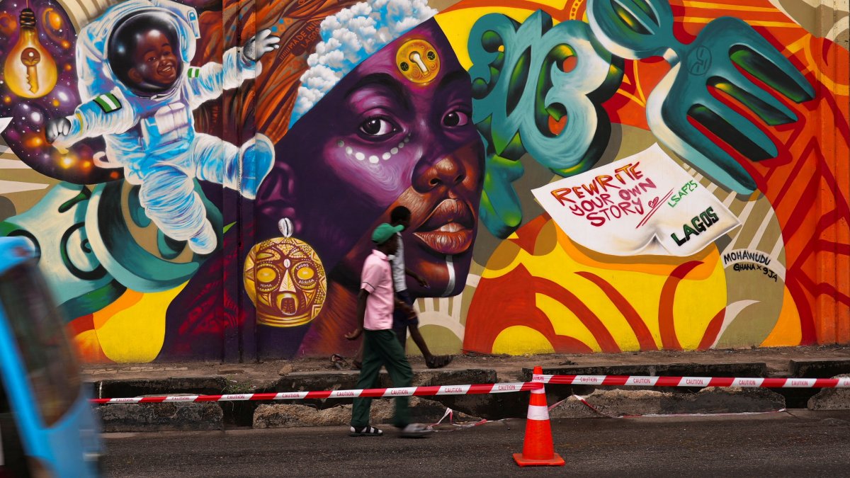 People walk past a mural on Ozumba Mbadiwe Way, during the Lagos Street Art Festival in Victoria Island, Lagos, Nigeria, Dec. 11, 2025. (Reuters Photo)