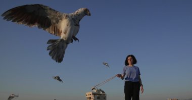 Loubna Hamdan stands on her loft&#039;s rooftop, where she leaves food out for pigeons, as she swings an empty slingshot to encourage them to fly and get exercise in Chiyah, the southern suburbs of Beirut, Lebanon, July 10, 2025. (AP Photo)