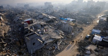 Palestinians walk past the rubble of destroyed buildings, amid a cease-fire between Israel and Hamas, in Gaza City, Nov.19, 2025. (Reuters File Photo)